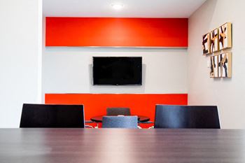 a conference room with a table and chairs and a television at The Foundry, Indiana, 46617